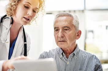Physician with Older Man and Phone